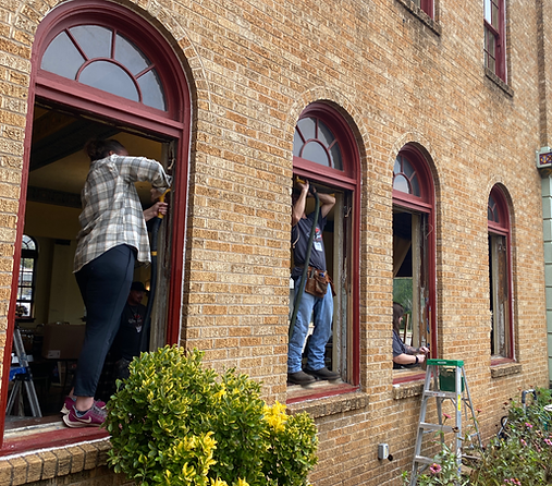 Craftspeople working on arched brick-framed windows