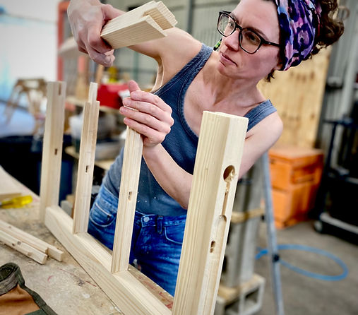 A craftsperson fitting mortise-and-tenon joinery on a new sash